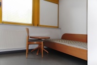 Einzelbett und Stuhl Kernbuche-Optik WG-Zimmer, gelbe Fensterrahmen mit Jalousien Einzelbett und Stuhl Kernbuche-Optik WG-Zimmer, gelbe Fensterrahmen mit Jalousien