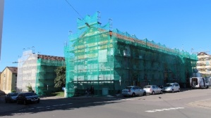 Zwei Wohnhäuser mit Gerüsten und Netzen.