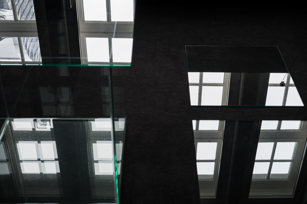 Reflexionen von Fenstern und Tageslicht in Glasscheiben in einem schwarzen Raum