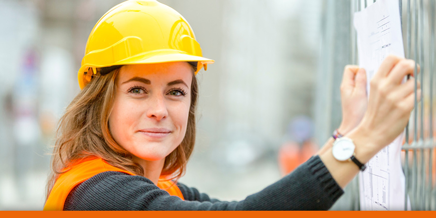 ZKE stellt ein und bildet aus Frau mit Bauhelm auf einer Baustelle hält einen Bauplan in den Händen. Foto: cineberg, adobe stock