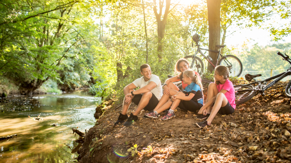 Fahrradtour Familie Pause am Bach nach einer Fahrradtour mit der Familie