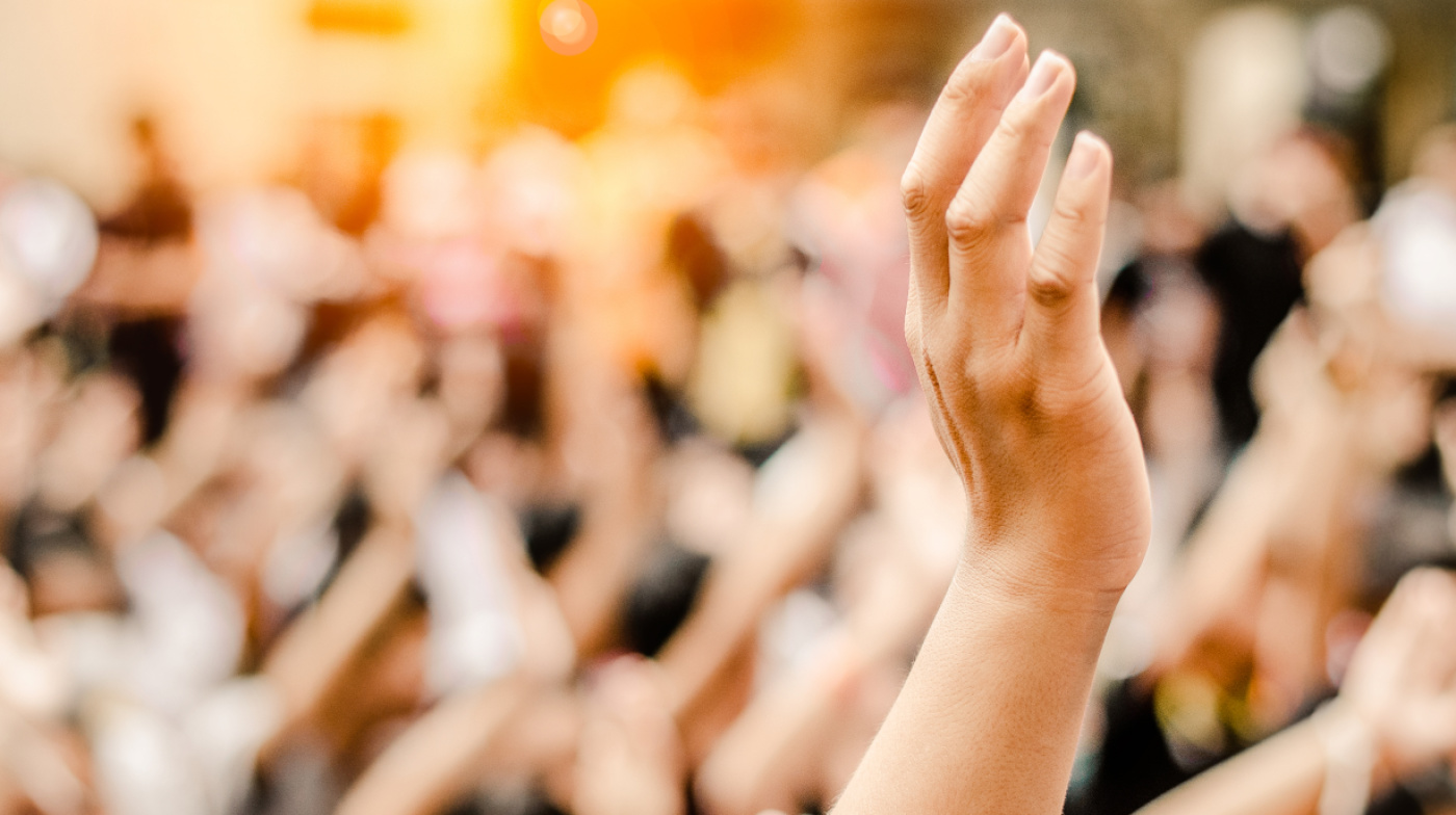 Symbolbild Bürgerbeteiligung mit erhobener Hand in der Menge