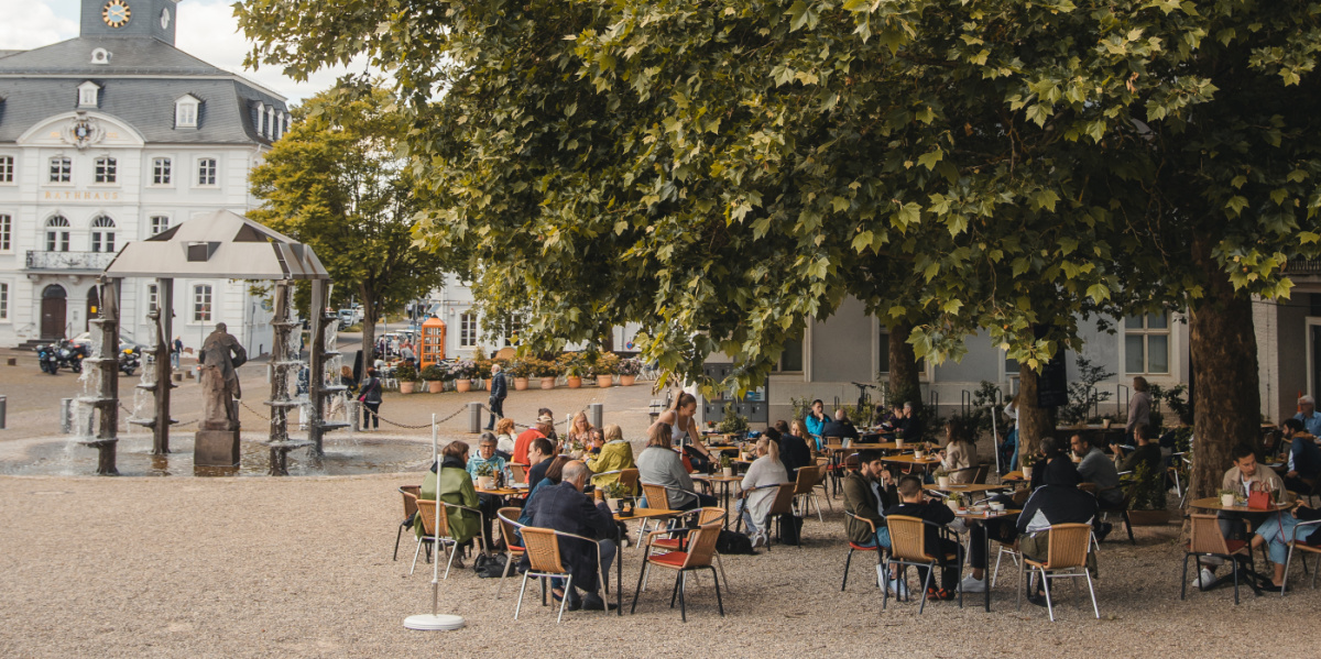 Café am Schloss Außenansicht Café am Schloss: Tische unter großen Baum mit Blick auf das Alte Rathaus Saarbrücken