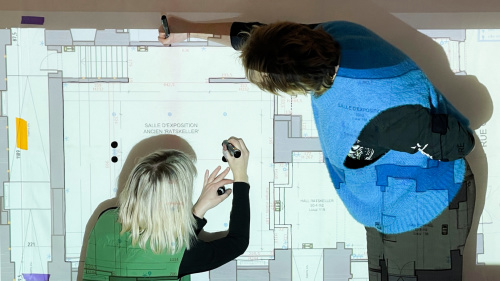 Zwei Personen zeichnen auf einen Raumplan