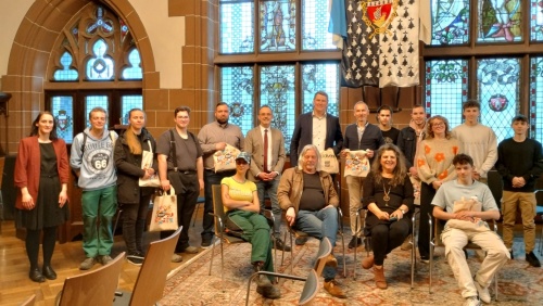 Eine Gruppe junger Leute und ihre Begleiter im Festsaal des Rathauses St. Johann