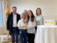 Mehrere Personen stehen in einem Raum, um sie herum befinden sich mehrere Einrichtungsgegenstände