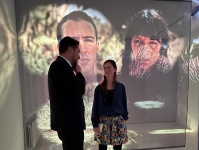 Zwei Personen stehen vor einer Leinwand, auf der eine Installation projiziert wird.