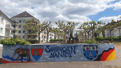 Eine Mauer bemalt mit dem Elefanten aus Nantes, den Stadtwappen Nantes-Saarbrücken und dem Schriftzug "Saarbrücken-Nantes"