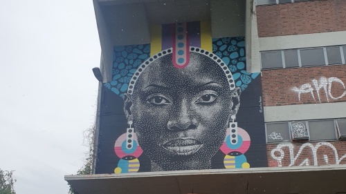 Gesicht auf den Mauern am Osthafen dargestellt mit pointillistischer Technik einer fiktiven Person 