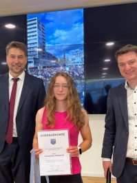 Junge Sportlerin in der Mitte mit Urkunde, links der Ob, rechts der Amtsleiter