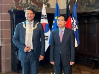 Zwei Männer stehen in feierlicher Kleidung in einem Festsaal