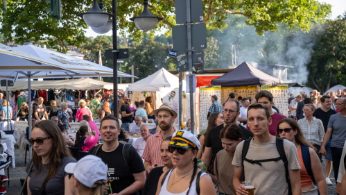 Altstadtfest 2025: Kunstmarkt Die Menschen schlendern vorbei an Marktstände, einige mit Getränken in der Hand. Im Hintergrund: weiße Marktzelte und Verkaufsstände.
