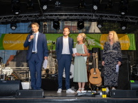 Zwei Männer und zwei Frauen stehen auf einer großen Bühne