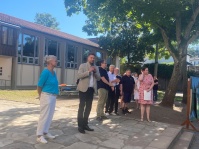 Eine Gruppe Erwachsener steht um einen Mann mit Mikrofon