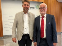 Zwei Männer in Anzügen posieren für ein Foto