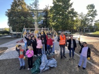 Kinder stehen mit Müllbeuteln und Sammelzangen auf dem Schulhof