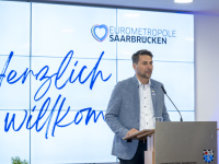 Eine Gruppe Menschen posiert vor einer Tafel für ein Gruppenbild 