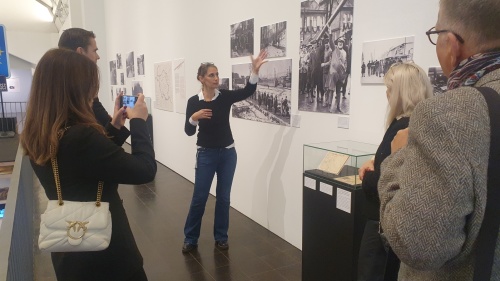 Eine Frau beschreibt ein Foto, mehrere Besucher stehen davor