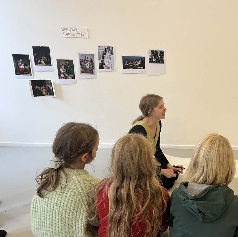 Kindersonntag vom 23.11.2025 Kunstvermittlerin und Kinder im Sitzkreis