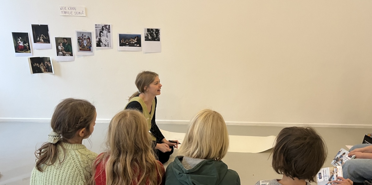 Kindersonntag vom 23.11.2025 Kunstvermittlerin und Kinder im Sitzkreis