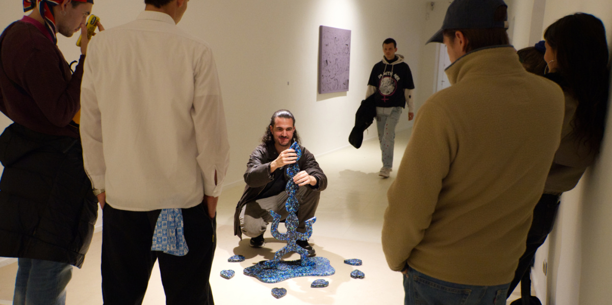 Menschen stehen um eine Skulptur herum und betrachten sie