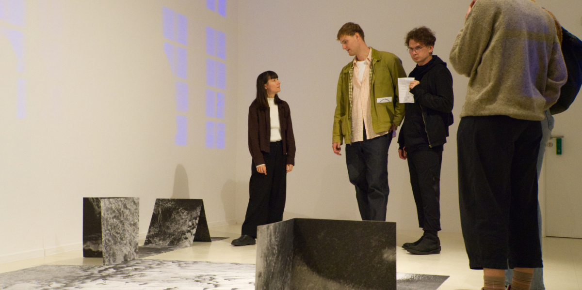 Menschen stehen um ein Bild herum und betrachten es