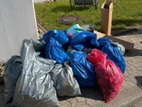 Eingesammelter Müll auf einem Fußweg, zur Abholung bereit