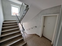 Etagenpodes im Treppenhaus, links Stufen nach oben, rechts Wohnungseingangstür